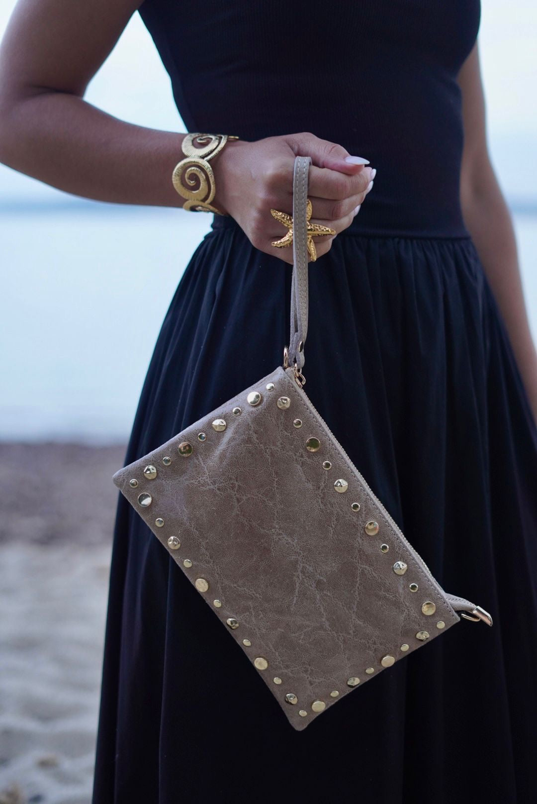 Pochette en cuir beige, ornée de clous dorés