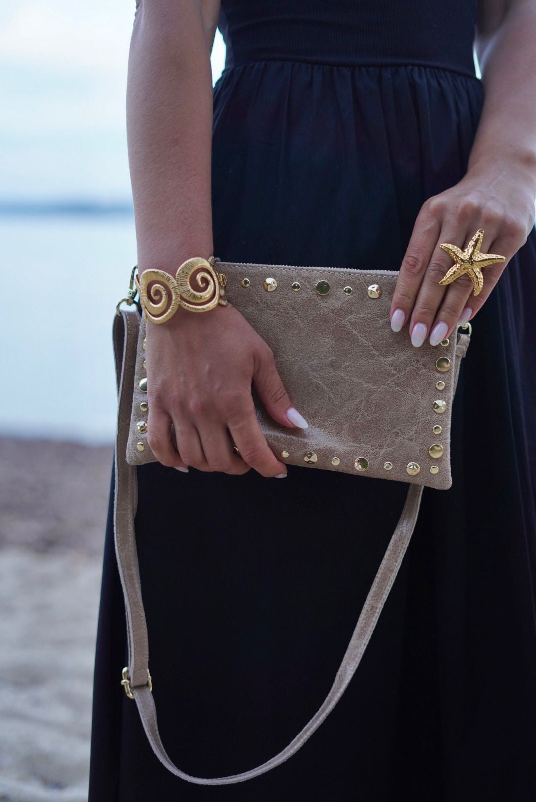 Pochette en cuir beige, ornée de clous dorés