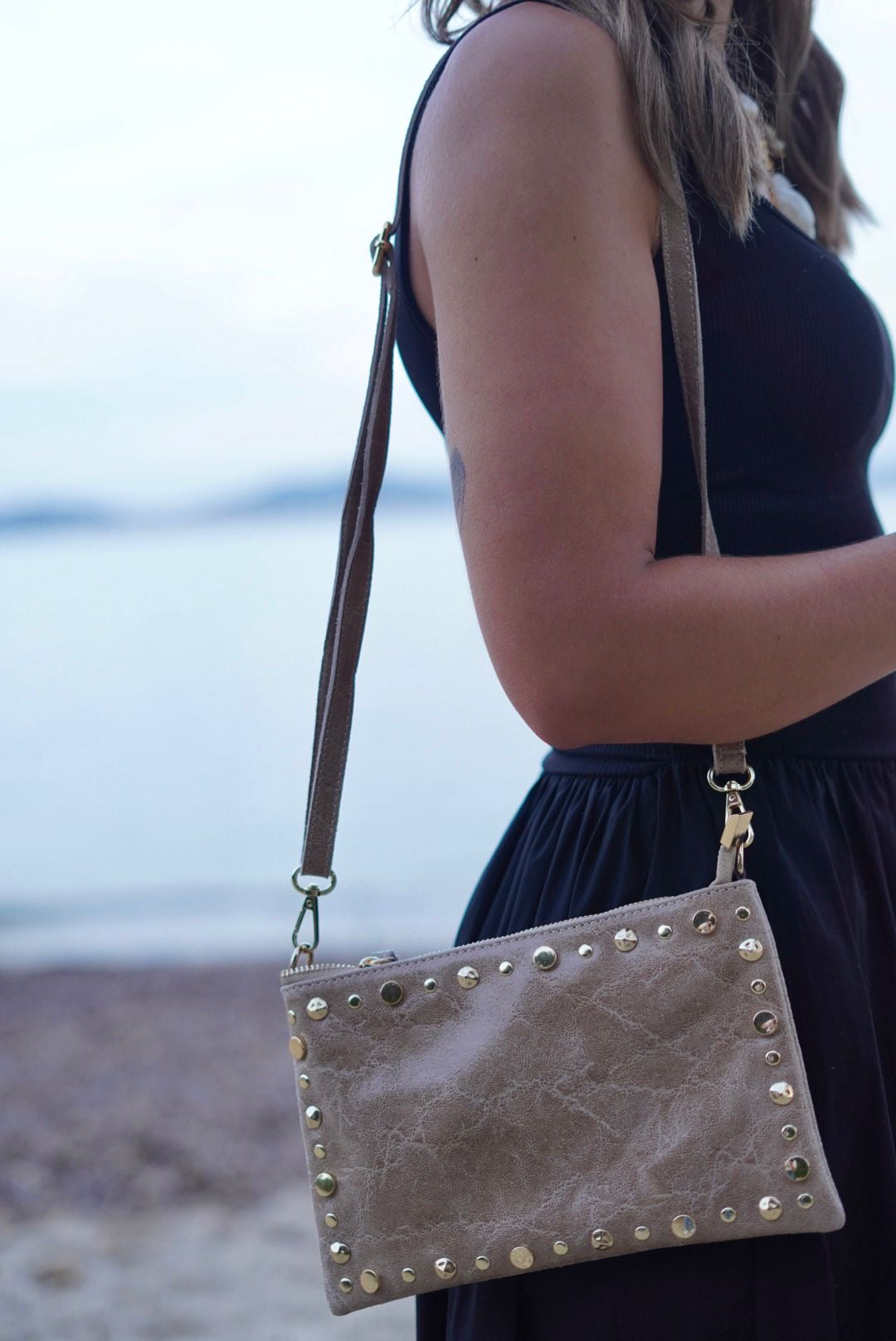 Pochette en cuir beige, ornée de clous dorés